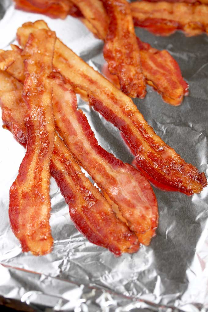 Bacon slices on a baking sheet pan.