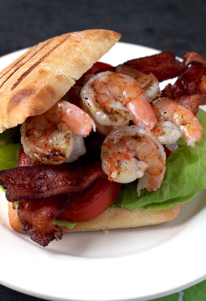 top view of a sandwich with grilled shrimp in herb aioli with tomatoes, bacon and lettuce 