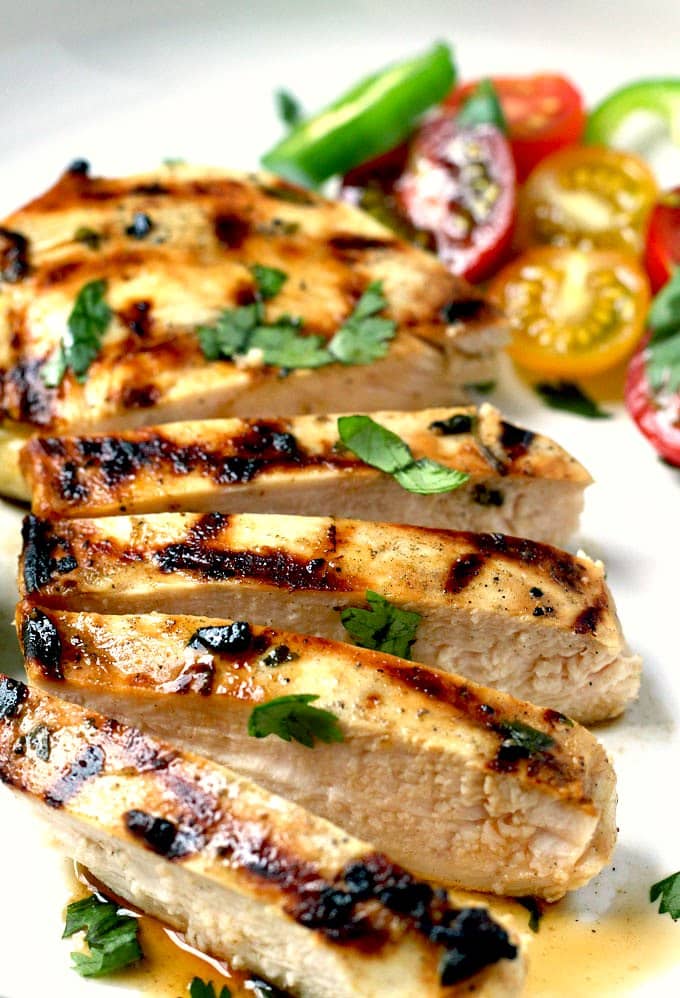 Close up of sliced  lime tequila chicken breast on a white plate.