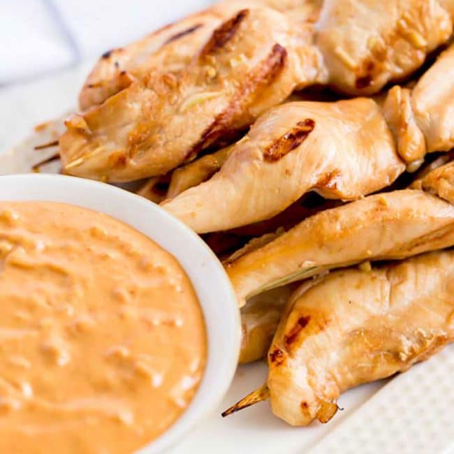 Grilled Chicken Skewers next to a bowl of dipping sauce