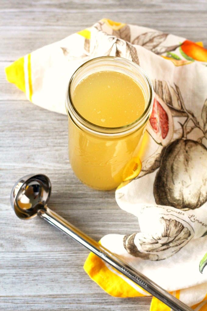 Chicken stock in a glass container.