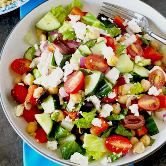 Crisp Chopped Greek Salad with Kalamata olives and Feta cheese on a white bowl.