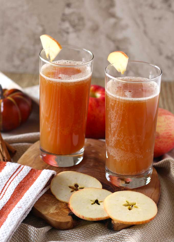 Two glasses of shandy garnished with apple slices