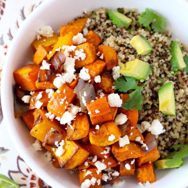 Vegetarian Mexican Buddha bowl with butternut squash and sweet potatoes over wholesome cilantro lime quinoa topped with cotija cheese and avocado