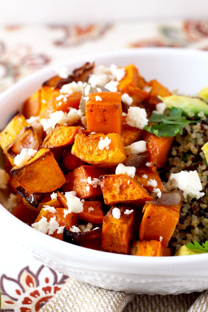close up view of Mexican Buddha bowl with butternut squash and sweet potatoes over wholesome cilantro lime quinoa topped with cotija cheese and avocado