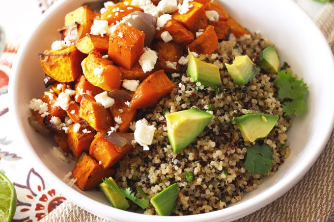 Vegetarian Mexican Buddha bowl with butternut squash and sweet potatoes over wholesome cilantro lime quinoa topped with cotija cheese and avocado