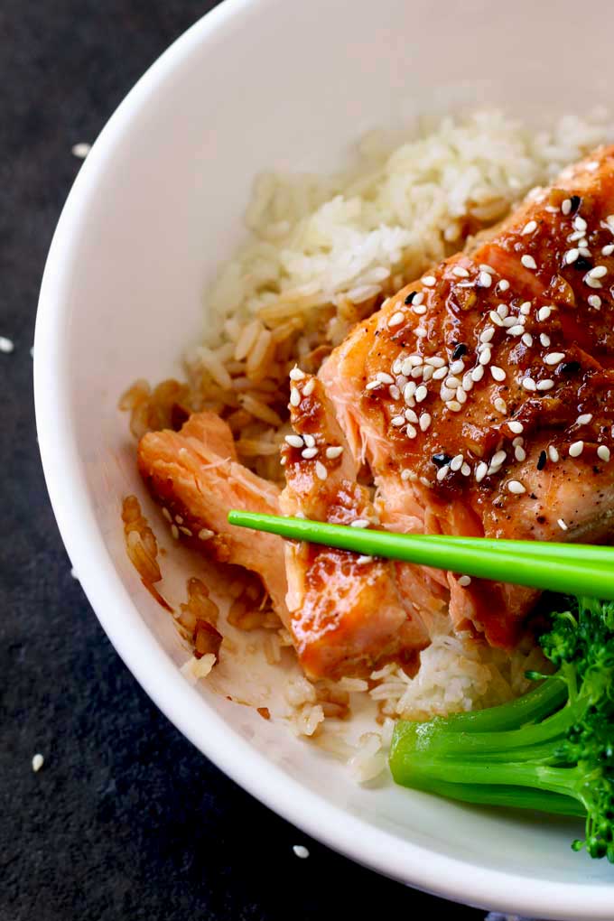 Flaked salmon fillet lift with chopsticks.