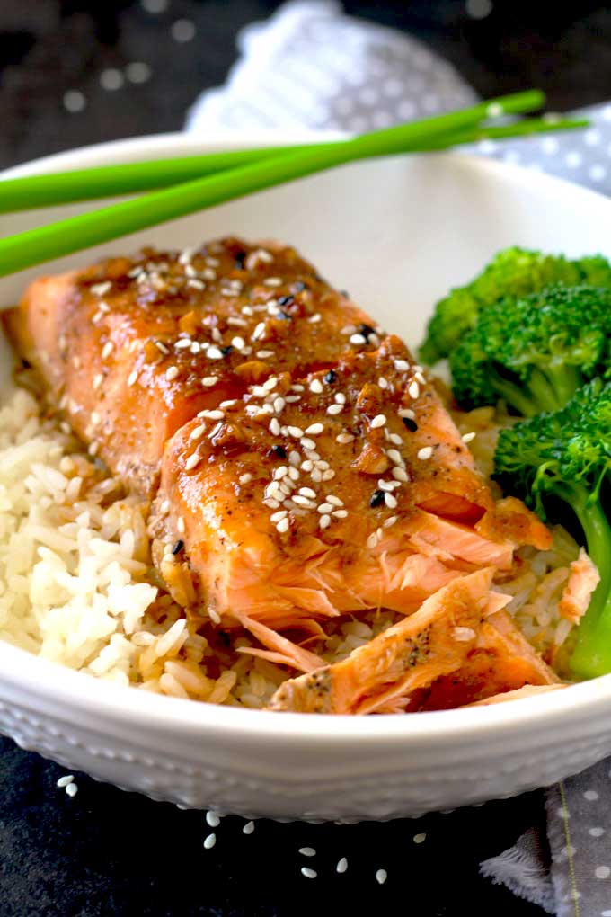 Baked Salmon over rice on a white bowl.