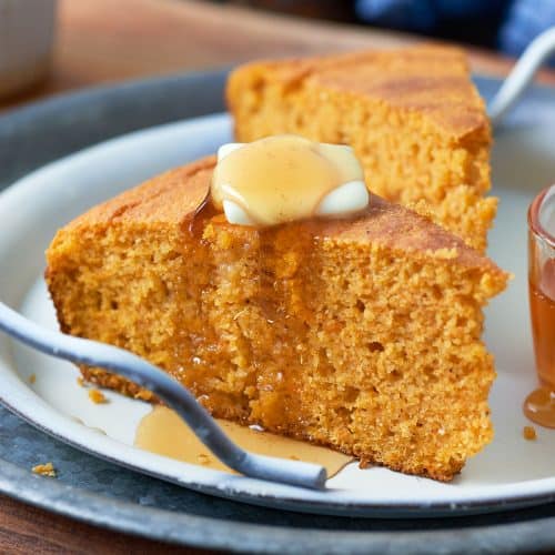 a slice of Sweet Potato Cornbread with honey and a piece of butter on top