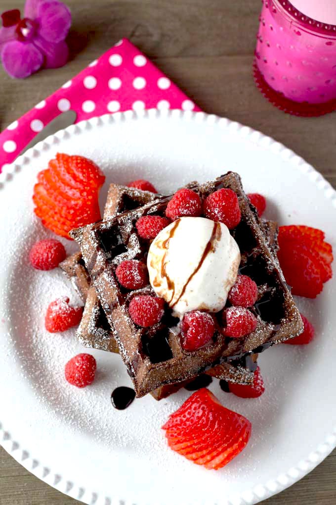 Overhead wiew of chocolate waffles on a white plate.