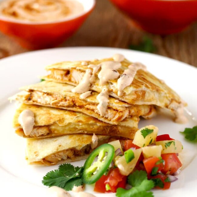 This easy to make Tex Mex inspired BBQ Chicken Quesadilla with Smoked Gouda Cheese is packed with super flavorful chicken and gooey cheese. Served with a delicious and fruity pineapple salsa and topped with a spicy and smoky Chipotle Crema! Let's sum that up in one word ~ Amazing!