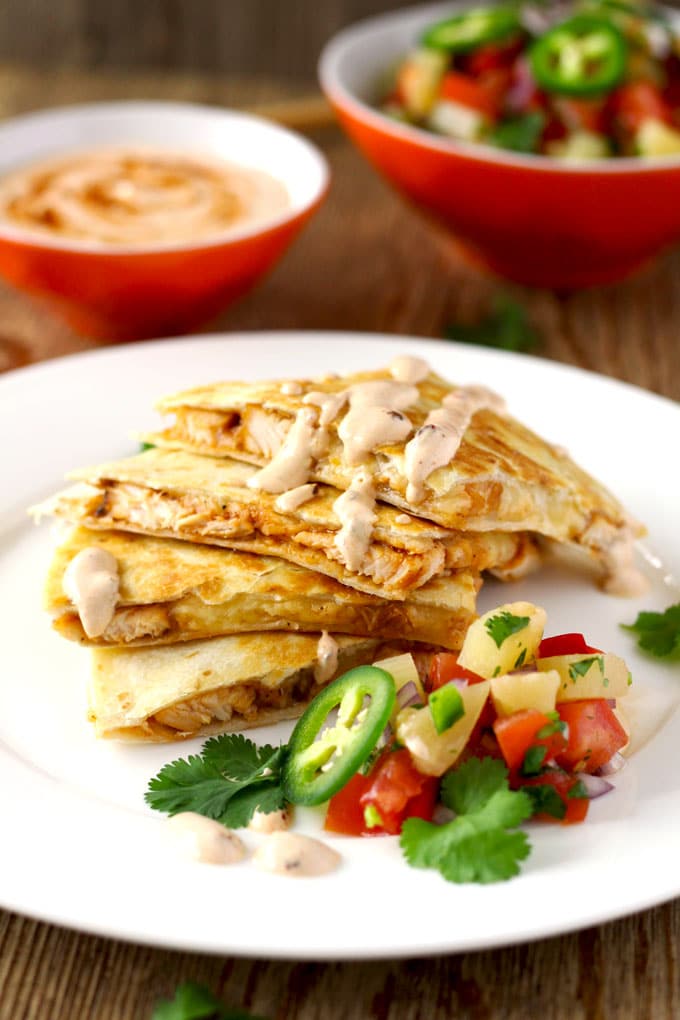 This easy to make Tex Mex inspired BBQ Chicken Quesadilla with Smoked Gouda Cheese is packed with super flavorful chicken and gooey cheese. Served with a delicious and fruity pineapple salsa and topped with a spicy and smoky Chipotle Crema! Let's sum that up in one word ~ Amazing!