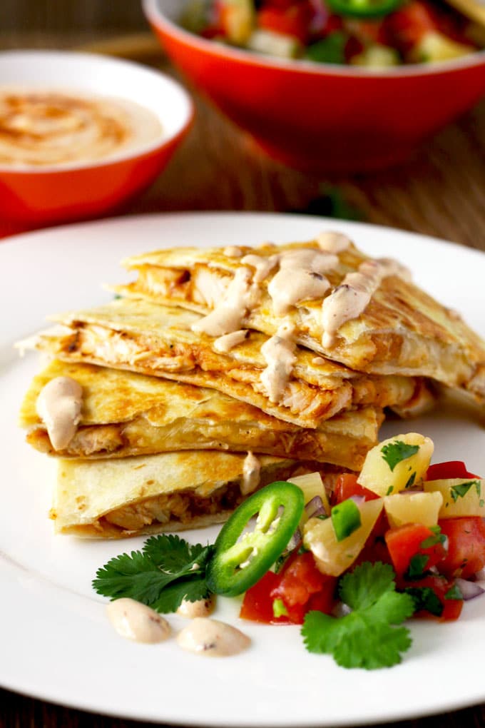 This easy to make Tex Mex inspired BBQ Chicken Quesadilla with Smoked Gouda Cheese is packed with super flavorful chicken and gooey cheese. Served with a delicious and fruity pineapple salsa and topped with a spicy and smoky Chipotle Crema! Let's sum that up in one word ~ Amazing!