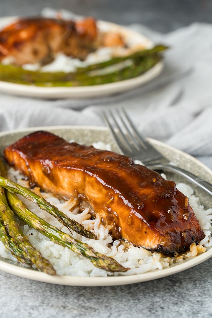 Miso glazed salmon served over rice with asparagus.
