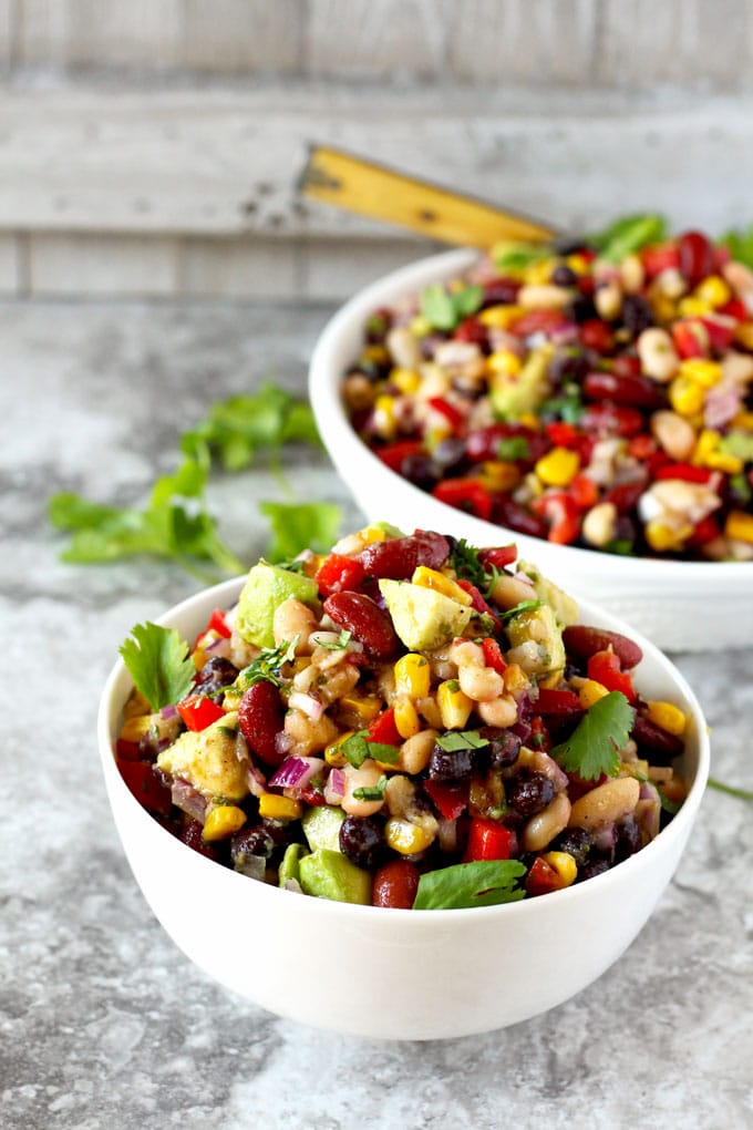 Two bowls of tasty protein-packed bean salad on a marble counter