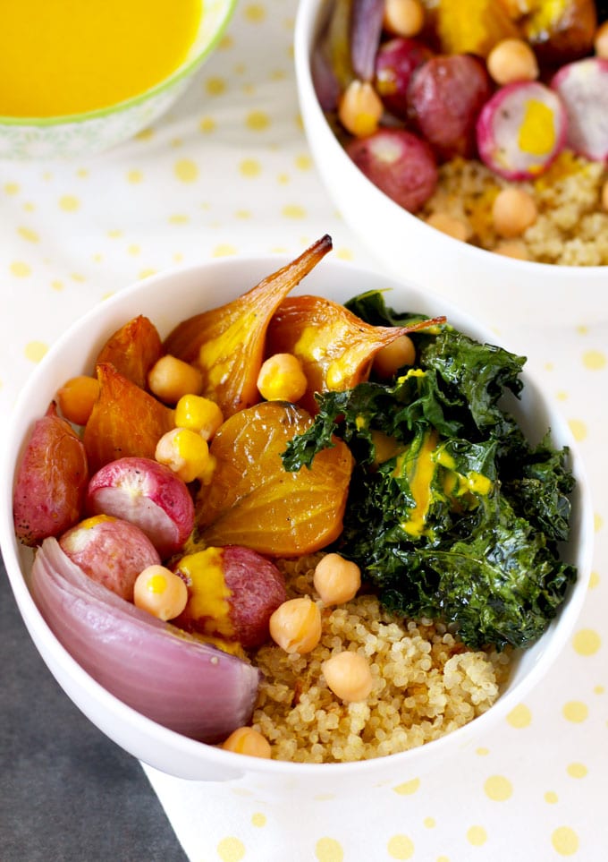 Overhead shot of a bowl with quinoa, caramelized radishes, golden beets, roasted kale and chickpeas.