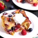 Tender and rich bread pudding topped with whip cream and garnished with fresh berries.