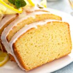 Close up slice of lemon pound cake with lemon glaze on a white plate.
