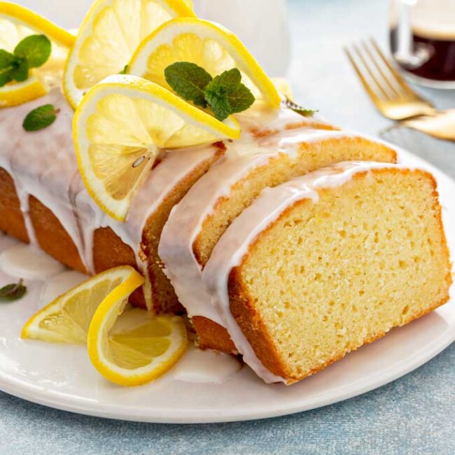 Lemon loaf drizzled with lemon glaze on a white plate