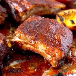 These BBQ Ribs in the Oven are seasoned with a simple rub mix and then smothered in a delicious lip-smacking Bourbon and Peach BBQ sauce. These foolproof oven baked ribs are incredibly delicious and fall off the bone tender!