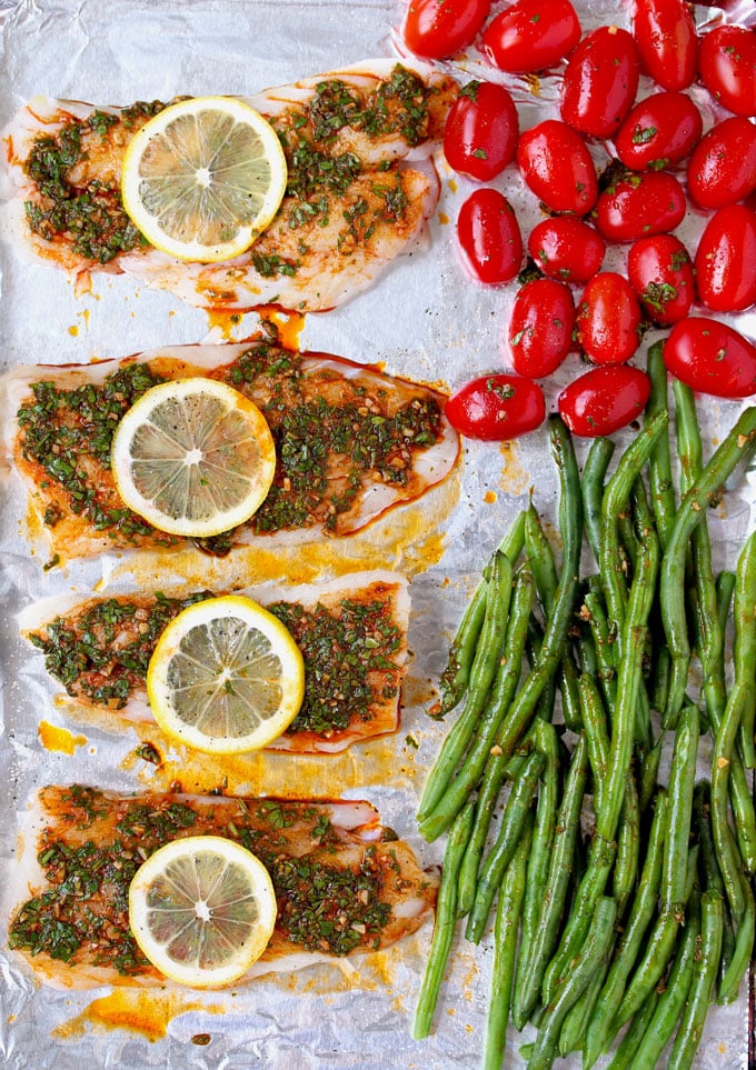 top view of lined up Baked cods garnished with lemon slices