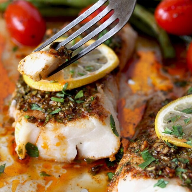 Wild Cod, Green Beans and Tomatoes are roasted to perfection with super flavorful Herb, Lemon and Garlic  Chermoula Sauce. This Moroccan inspired flavor-packed baked cod recipe is cooked in less than 22 minutes!