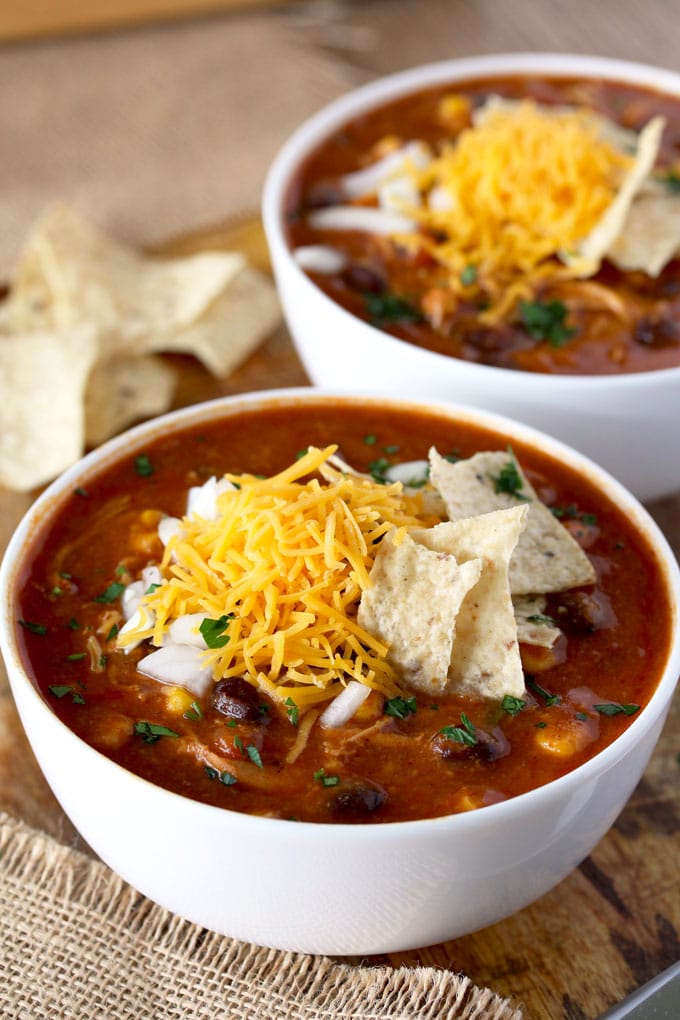 This Slow Cooker Chicken Enchilada Soup is bursting with flavor! Cheesy, creamy and full of shredded chicken, black beans and corn. With only 10 minutes of prep time this soup is pure comfort in a bowl!