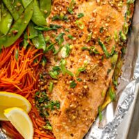 Succulent salmon fillet with shredded carrots and snow peas baked in foil