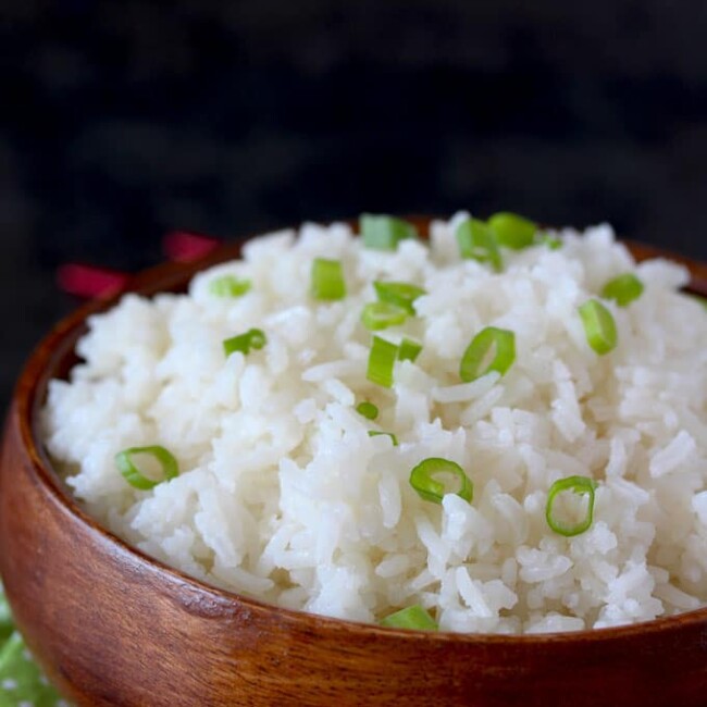 Light and fluffy cooked Jasmine with Gingered and Lemongrass in a wooden bowl garnished with thinly sliced green onions