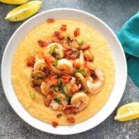 Top view of a bowl of creamy grits topped with shrimp.