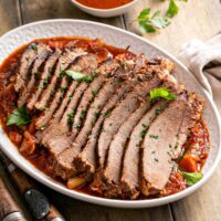 Tender sliced brisket of beef on a bed of vegetables and sauce