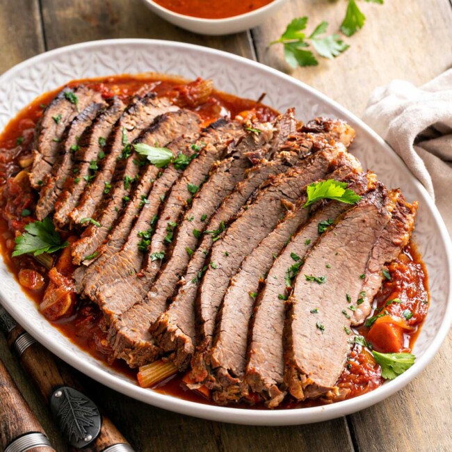 Tender sliced brisket of beef on a bed of vegetables and sauce