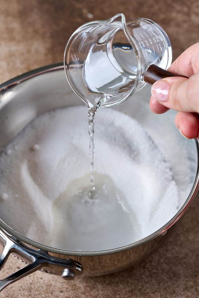 pouring water on a pan with sugar