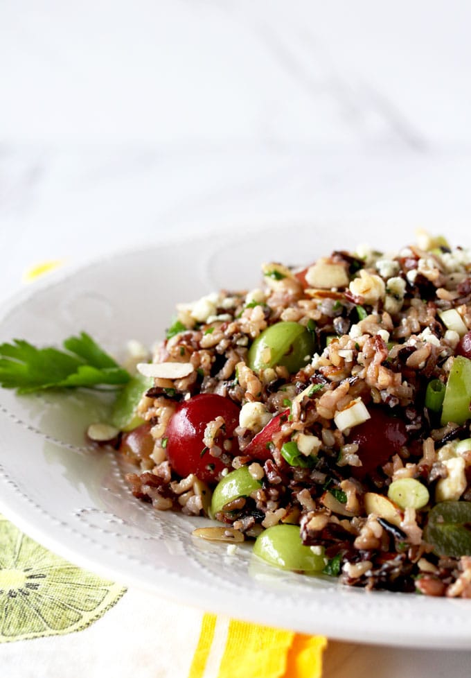 Close Up view of Wild Rice Salad on a white platter. Wild Rice Salad with Grapes, Almonds and Blue Cheese tossed in a Citrus Miso Vinaigrette