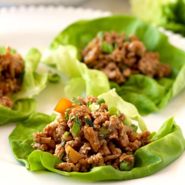 Pictured here a close up view of the Asian chicken lettuce wrap filling on top of a butter lettuce leaf