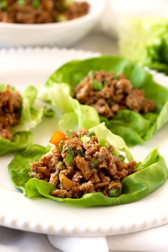 Pictured here a close up view of the Asian chicken lettuce wrap filling on top of a butter lettuce leaf