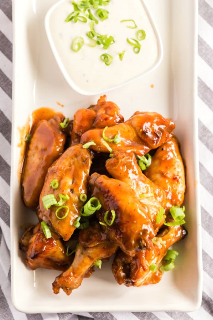 Crock Pot Wings on a white plate served with a dipping sauce.