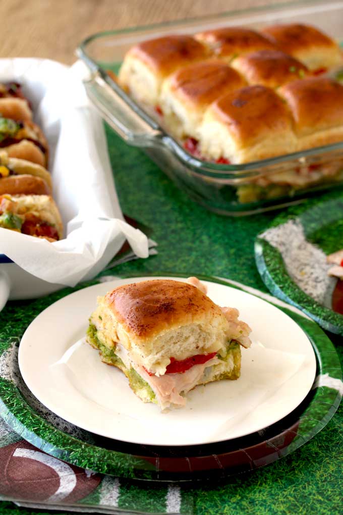 A Turkey Pesto Slider set on a table filled with other Game Day Foods