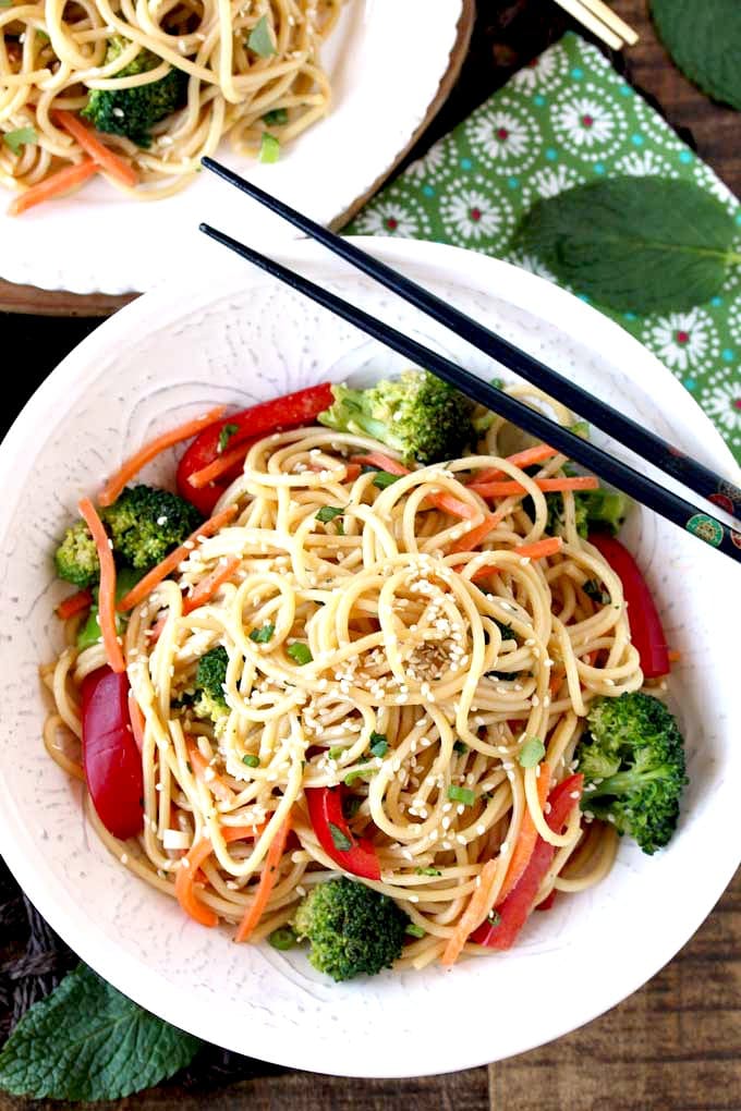 Top view of Asian noodles getting lift with chopsticks.