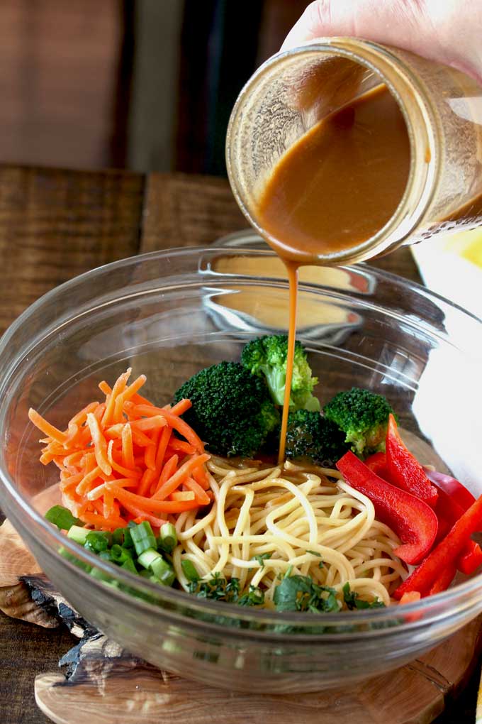 Peanut Sesame Dressing poured over noodles and vegetables.