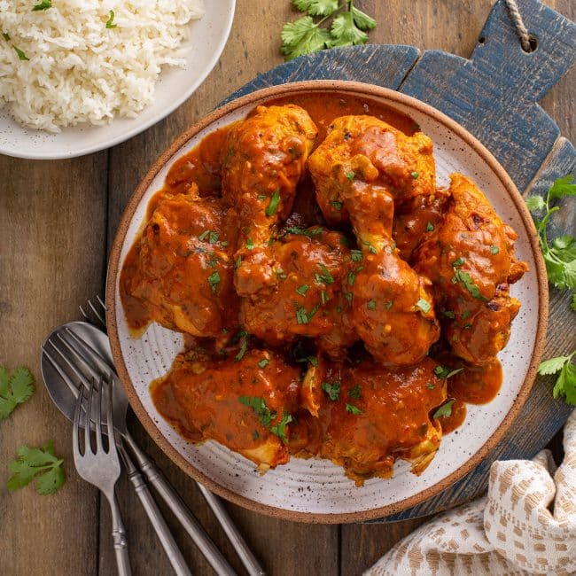 Chicken pieces in a tomato masala sauce on a plate