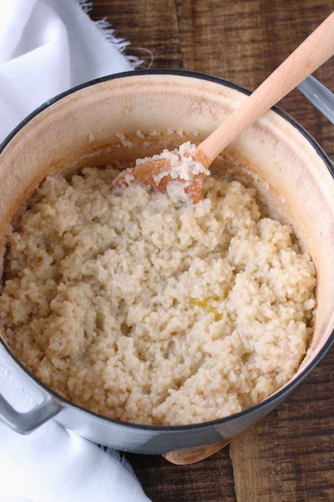 Risotto in a Dutch oven after adding the wine and butter