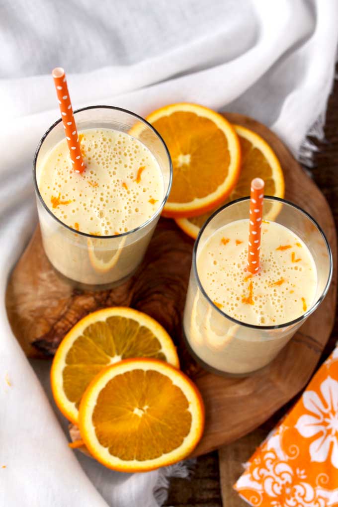 Top view of two glasses filled with Orange Honey Lassi