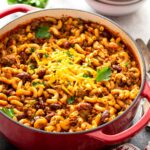 Chili macaroni and cheese or chili mac in a red Dutch oven pot