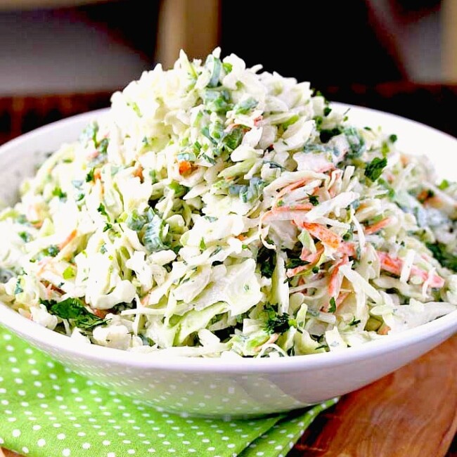 Creamy coleslaw pile up high on a white bowl