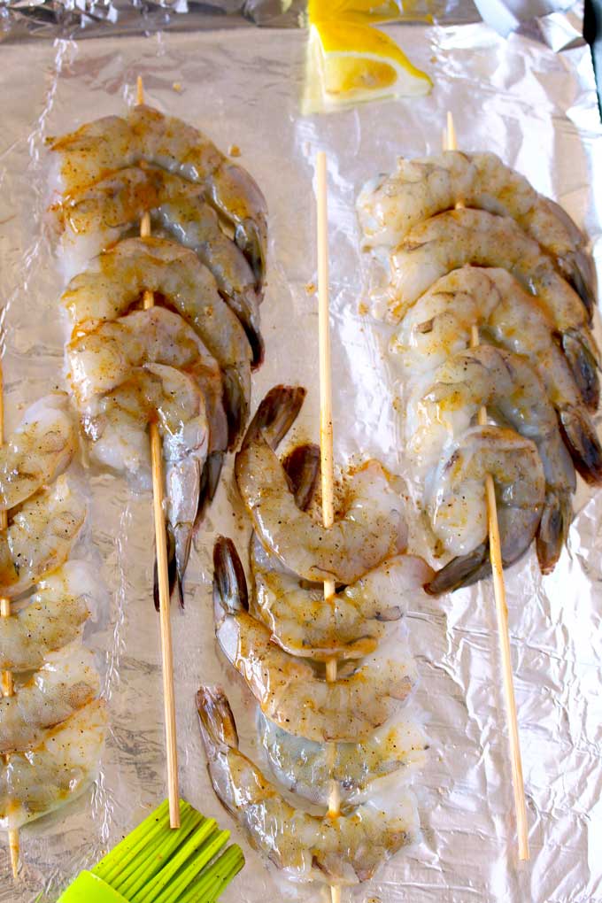 Raw shrimp skewered on a sheet pan