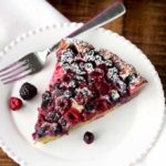 A slice of mixed berry clafoutis on a white plate