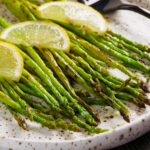 Grilled asparagus drizzled with lemon garlic butter and topped with lemon slices