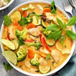 Bowl of curry Thai chicken with vegetables and fresh herbs