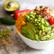 A white bowl filled with chopped ahi tuna and fresh veggies and fruit over rice.